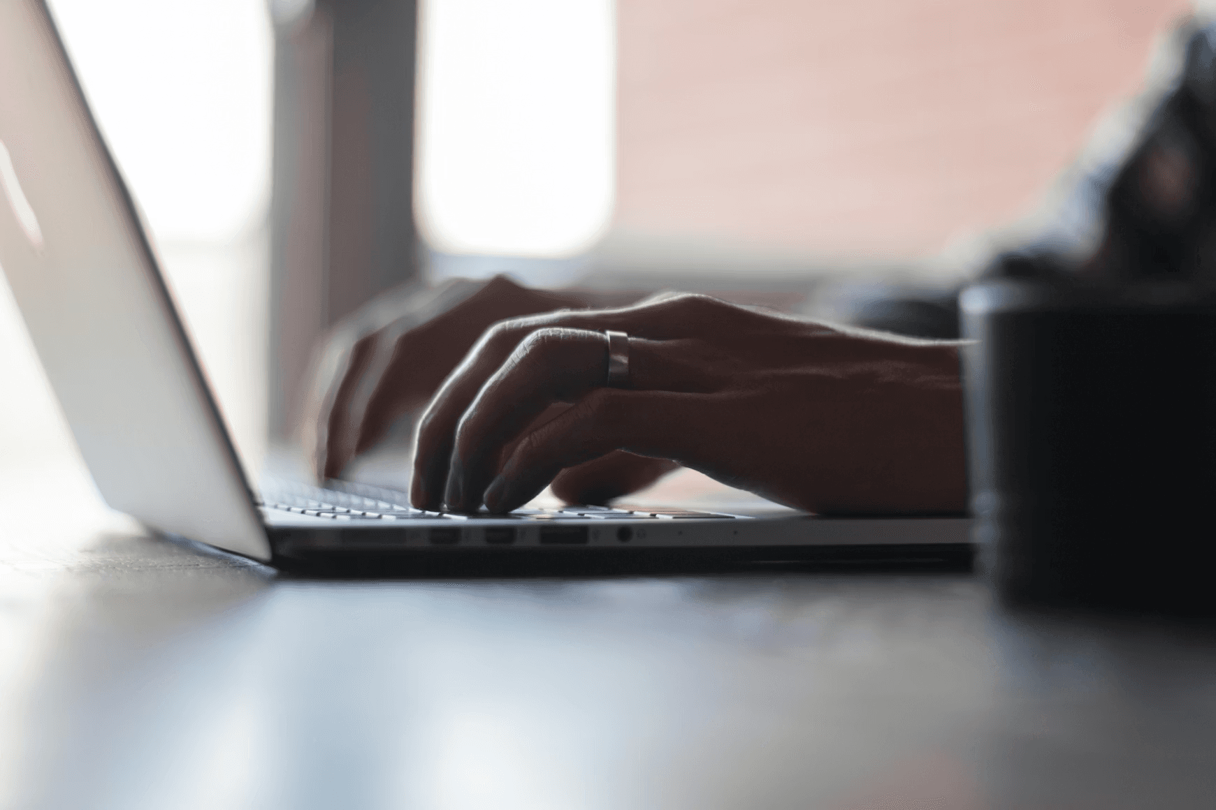 A person typing on a laptop in low light